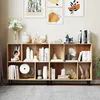A wooden bookshelf filled with decorative items and books, placed in a room with artwork on the wall. Podgląd zdjęcia produktu