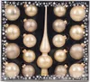 A set of champagne-colored Christmas ornaments and a tree topper, arranged in a black box with snowflake decorations on the border. Produktbild-Vorschau