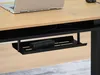 A laptop and a power adapter are shown on a desk with an under-desk shelf. Podgląd zdjęcia produktu