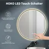 A hand is touching a round LED mirror with integrated lighting, showcasing its touch controls. Voir les images du produit