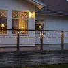 A house with a deck decorated with icicle lights. Podgląd zdjęcia produktu