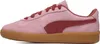 A side view of a pink Puma sneaker with red accents and a gum sole. Produktbild-Vorschau