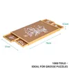 A puzzle board with several drawers, partially filled with puzzle pieces. Produktbild-Vorschau