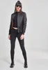 A woman is posing in a studio setting against a plain background, wearing a black bomber jacket and black jeans. Produktbild-Vorschau