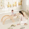 A mother and child playing with a wooden climbing set indoors. Produktbild-Vorschau