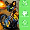 A stained glass cat lamp is displayed on a wooden surface, with marketing icons and text on a green background to the right. Produktbild-Vorschau