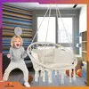 A child is excitedly posing next to a hanging chair in a room with striped wallpaper and a window. Náhled obrázku produktu