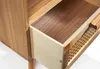 Close-up view of an open wooden drawer and a woven shelf on a piece of furniture. Produktbild-Vorschau