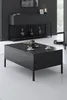 A modern living room scene featuring a black coffee table with two cups and a teapot, and a black sideboard in the background. Produktbild-Vorschau