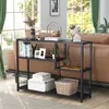 A black console table with various decorative items and books is placed behind a brown sofa in a living room setting. Podgląd zdjęcia produktu