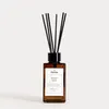 A brown glass diffuser bottle with black reeds and a white label. Náhľad obrázku produktu