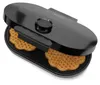 A black waffle maker with two heart-shaped waffles inside, shown from a slightly elevated angle. Podgląd zdjęcia produktu