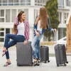 Two young women with luggage, appearing to be at a hotel or travel destination. Produktbild-Vorschau