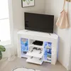 A white corner TV stand with a television and gaming accessories. Voir les images du produit