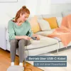 A woman is sitting on a couch and plugging a USB-C cable into a device. Anteprima dell’immagine prodotto