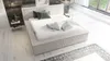 A modern bedroom with a bed, nightstand, and rug. Produktbild-Vorschau