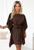 A woman models a brown dress in a studio setting. Produktbild-Vorschau