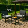 A patio set with two chairs and a table on a paved patio, with a garden and gazebo in the background. Produktbild-Vorschau