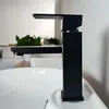 A black faucet is shown in a bathroom setting, positioned over a white sink. Podgląd zdjęcia produktu