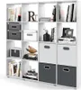 A white cube shelf unit filled with books, storage boxes, and decorative items. Náhled obrázku produktu