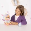 A young girl is playing with a doll on a table. Anteprima dell’immagine prodotto