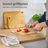 A person is chopping vegetables on a cutting board in a kitchen setting. There are multiple cutting boards and a spoon visible. Anteprima dell’immagine prodotto