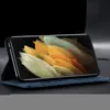 A smartphone in a blue flip case, displayed on a dark surface. Produktbild-Vorschau