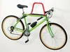 A green bicycle is mounted on a wall using a red and black bike rack. Produktbild-Vorschau