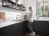 A woman is using a kitchen faucet in a modern kitchen. Produktbild-Vorschau