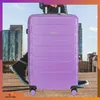 A person holding a purple suitcase on a rooftop with city buildings in the background. Náhled obrázku produktu