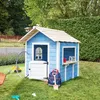 A blue wooden playhouse in a grassy backyard with toys around it. Náhled obrázku produktu