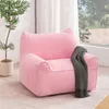 A pink beanbag chair with cat ears sits in a room near a window, with a plant and a blanket. Náhled obrázku produktu