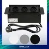A black retractable power strip with three outlets is shown, along with three circular color swatches (white, gray, black) and a power cord with a plug. Produktbild-Vorschau
