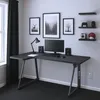 A black L-shaped desk with a computer setup in a room with minimalist decor. Podgląd zdjęcia produktu