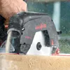 A person is using a Mafell K 55 cc hand circular saw to cut wood, with sawdust flying. Produktbild-Vorschau