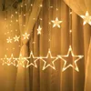 A string of star-shaped LED lights hanging in front of curtains. Podgląd zdjęcia produktu
