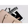 A collection of items, including a selfie stick, smartphone, tablet, lipstick, and pen, are placed inside an open handbag. Podgląd zdjęcia produktu