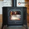 A black cast iron wood-burning stove with a fire burning inside, set against a white brick wall and wooden floor. Náhľad obrázku produktu