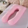 A pink U-shaped pregnancy pillow is laid out on a bed with a white sheet. Produktbild-Vorschau