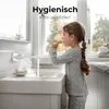 A young girl brushing her teeth at a sink with a wall-mounted faucet. Podgląd zdjęcia produktu