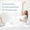 A woman is stretching in bed with a pillow, surrounded by white bedding. A graphic overlay lists product features. Produktbild-Vorschau