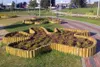 A park setting with flower beds bordered by wooden logs. Produktbild-Vorschau