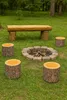 An outdoor seating area with a fire pit, log bench, and log stools. Podgląd zdjęcia produktu