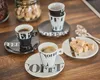Espresso cups and saucers with sugar cubes on a wooden table. Anteprima dell’immagine prodotto