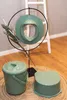 A potty training seat, a bucket, and a step stool are displayed on a woven mat in front of a white ladder. Produktbild-Vorschau