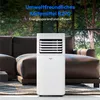 A white portable air conditioner is placed in a living room in front of a brown leather sofa, with trees and windows in the background. Produktbild-Vorschau