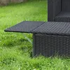 A close-up view of a black rattan outdoor furniture set, specifically a table or bench with a foldable extension, set on a grassy lawn. Podgląd zdjęcia produktu