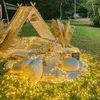 A decorated outdoor picnic setup with a tent, pillows, and string lights. Voir les images du produit