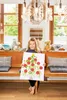 A young girl is holding up a Christmas tree painting made with handprints. Anteprima dell’immagine prodotto