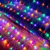 A net of colorful LED lights draped over a dark blue surface and a wooden floor. Produktbild-Vorschau